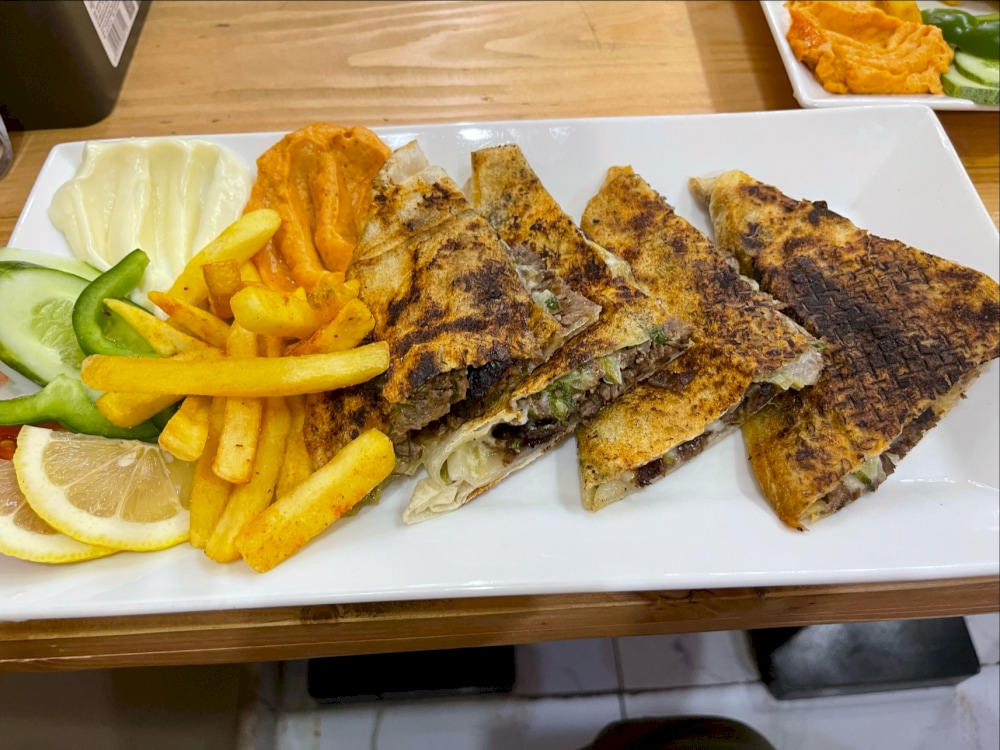 A plate of Hawawshi filled bread with French fries